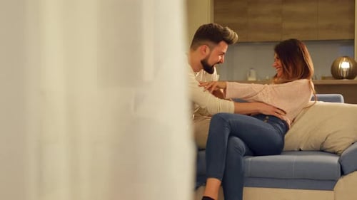 Happy Couple Laughing Together on Corner Couch