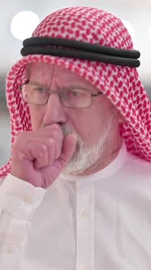 Senior Man Coughs into Fist Indoors