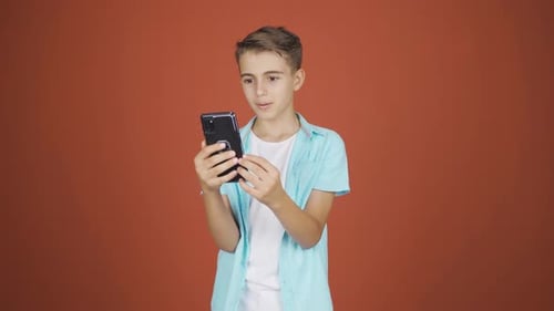 Teen Using Smartphone on Red Background