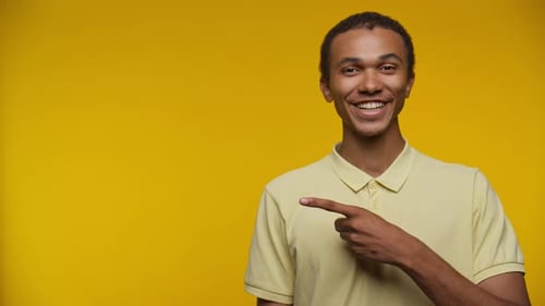 Smiling Man Points to Empty Space on Yellow