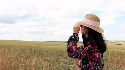 Girl In A Hat On A Rural Landscape With Golden Fields. Tracking Shot