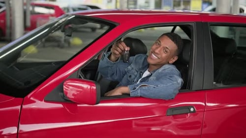 African American Man Showing Car Key Sitting in Red Automobile Slow Motion