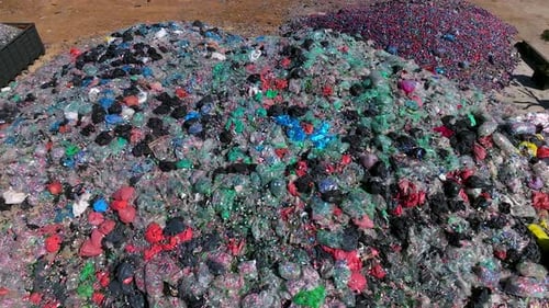 Plastic bottles and Trash Soda cans recycling piles in a local facility, Top down view