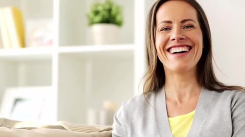 Smiling woman looking at camera in bright living room