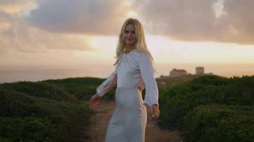 Woman in Dress Walking at Sunset by the Ocean
