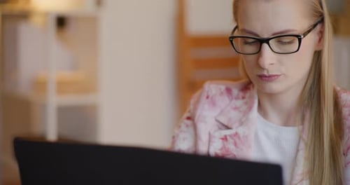 Woman Working on Laptop Computer in Home Office