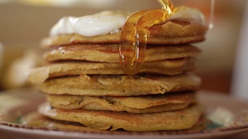 Pouring Honey on Pancakes Stacked in Pile, Slow Motion in Extreme Close Up