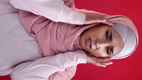 Woman in Hijab with Hands to Head