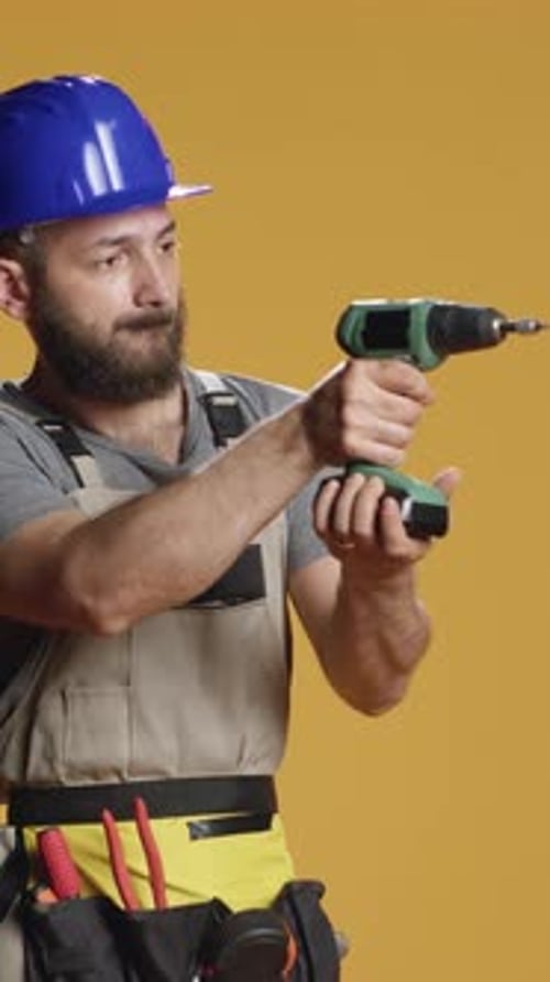 Vertical Video Portrait of Repairman Builder Using Electric Power Drill Machine