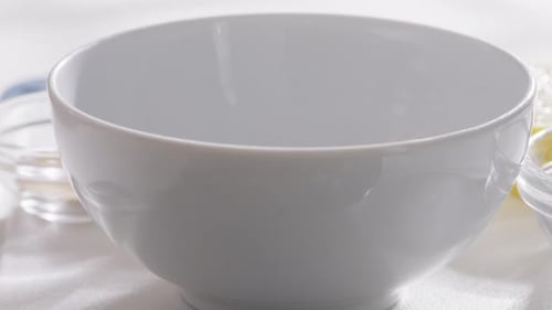 Creamy Yogurt Being Poured Into a White Bowl