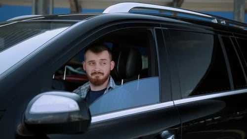 Man Sitting in Black Car Driver Seat