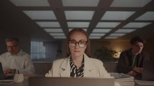 Empresária confiante trabalhando no laptop na mesa no espaço de escritório moderno