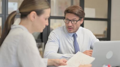 Adults Discussing Work in an Office Setting