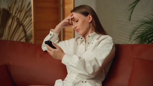 Woman in White Jumpsuit Upset About Phone