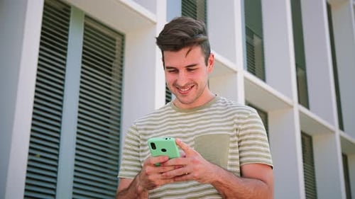 Young Adult Man Using Phone in the City