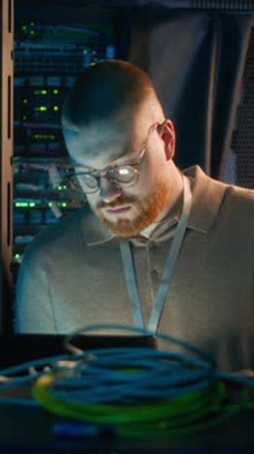 Engineer Works in Brightly Lit Server Room
