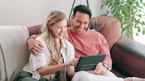 Happy Couple Using Tablet on Sofa Together