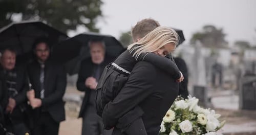 Girl Hugging Man at Outdoor Cemetery Funeral