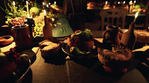 Festive Table with Food and Drinks at a Candlelit Gathering