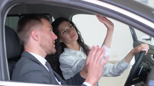 Man and Woman Discussing Car Features in Showroom