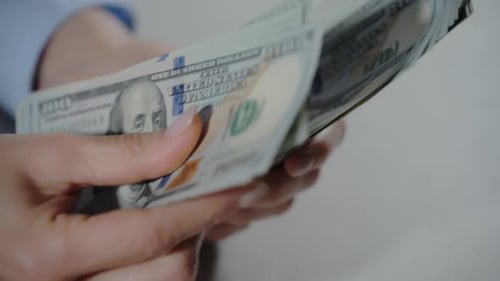 Close Up View of Female Hands Counting Money Holding Hundred Dollar Bills