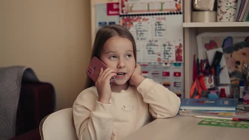 Girl Talking on Cellphone at Desk Indoors