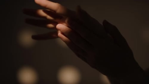 Woman's Hands Rubbing Together in Moody Light