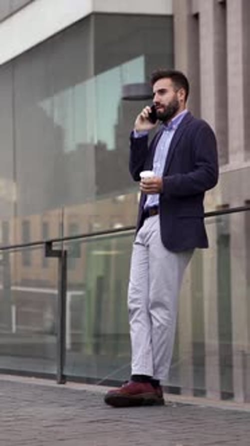 Man Talking on Phone with Coffee in Urban Setting