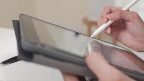 close up of woman hands drawing using tablet pc touch screen technology holding stylus pen