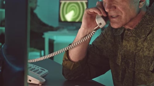 Adult Man in Camouflage Talking on a Phone