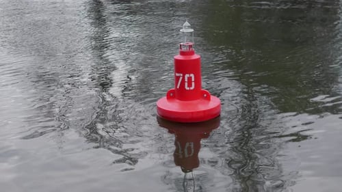 Eine rote Boje, die eine Navigationspunktmarkierung in ruhigen und ruhigen Gewässern auf See kennzeichnet