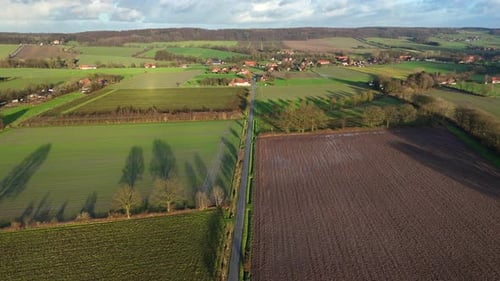 Rural Landscape with straight street in american countryside. Golden sunset time with small village
