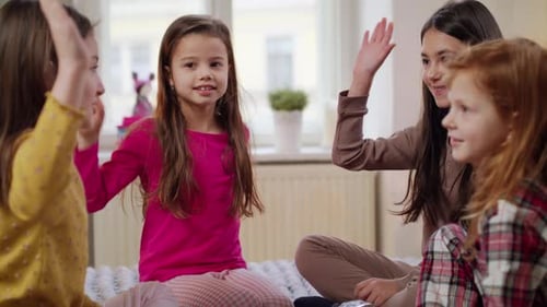 Four Girls Sit Together Playing a Hand Game