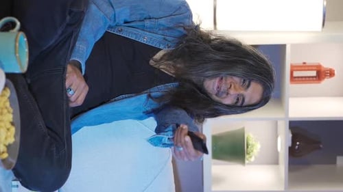 Man Relaxes with Snacks and TV at Home