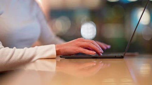 Die Hand einer Frau, die auf der Laptoptastatur tippt — Detail der digitalen Arbeit