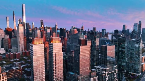 Skyscrapers with pink light on the facades at sunset.