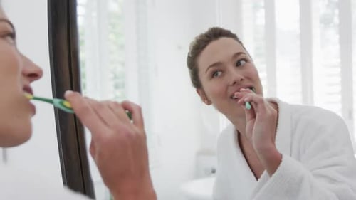 Young Woman Brushing Teeth in Bright Bathroom