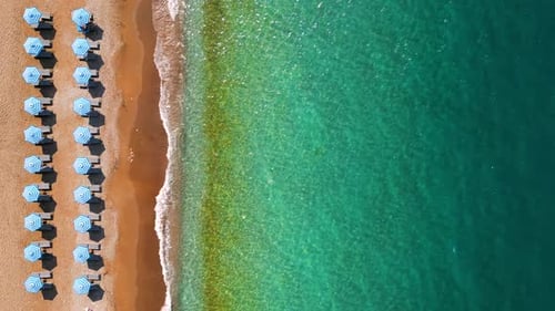 Topdown View of Sandy Beach with Sun Umbrellas and Turquoise Sea Water