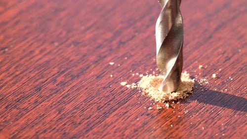 Drill Bit Boring into Wood Plank