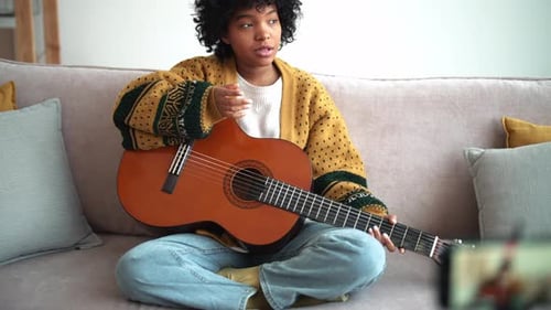 Young Woman Explains Guitar on Video Call