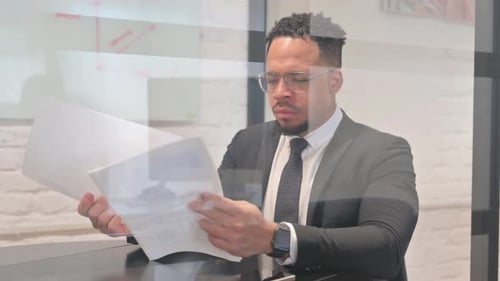 Man Reviews Documents in Modern Workplace