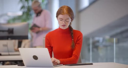 Woman Typing on Laptop in Modern Office