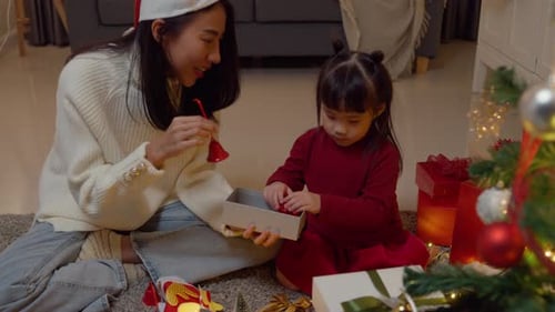 Mother and Child Decorate Christmas Tree with Ornaments