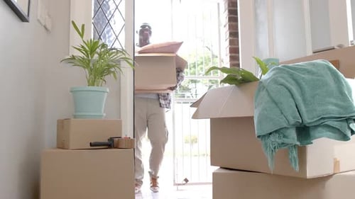 Man Carrying Moving Box Into New Home