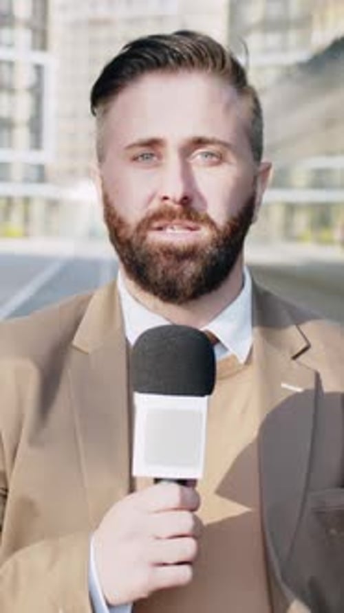Reporter with Microphone Speaking to Camera Outside