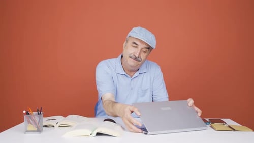 Old man joyfully embracing laptop.