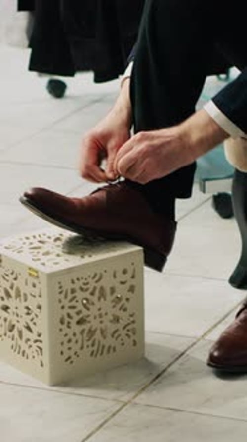 Well Dressed Man Tying Shoe Laces in Store