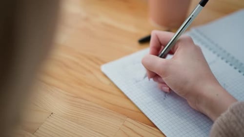 Hand Writes in Notebook with Black Pen