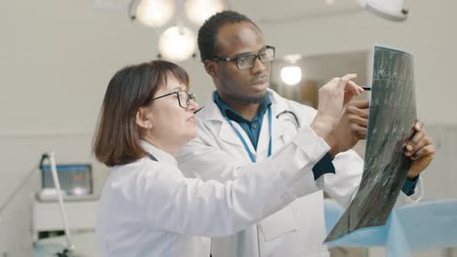 Healthcare Professionals Examining X-Ray Film in Hospital