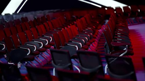 Empty Rows of Modern Black Chairs with Metal Legs Line a Large Auditorium Seen From Diagonal Angles